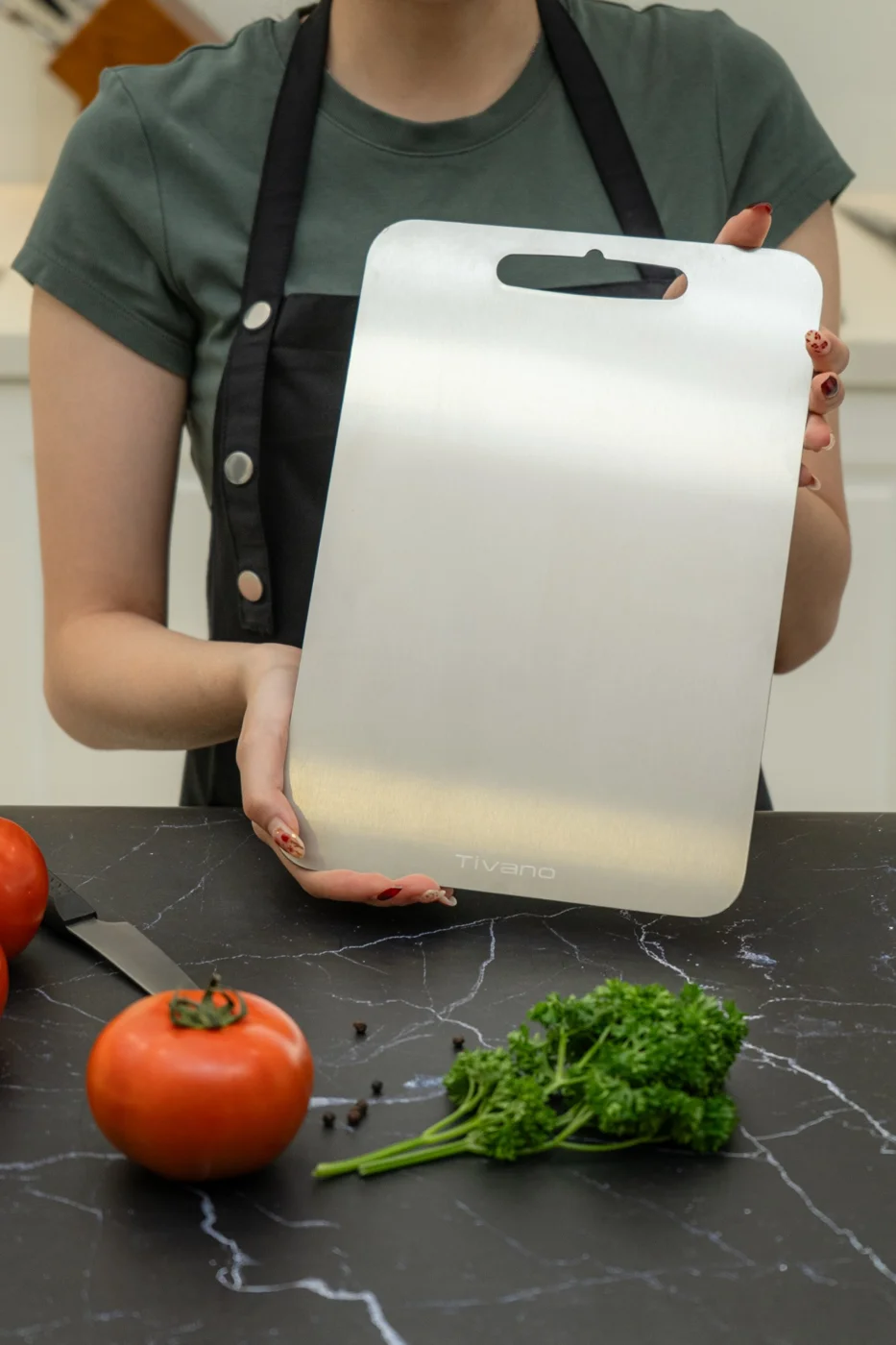A person holding Tivano Cutting Board upright by its edges