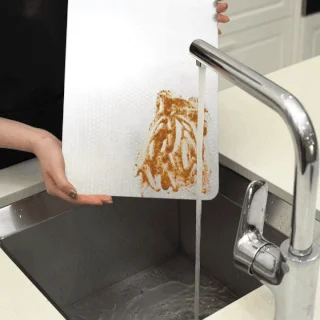 Tivano Cutting Board being rinsed over a kitchen sink in supplier media